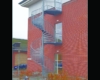 Udendørs spindeltrappe i stål ved Tietgenskolen foran rød murstensmur. Trappen er en brandtrappe